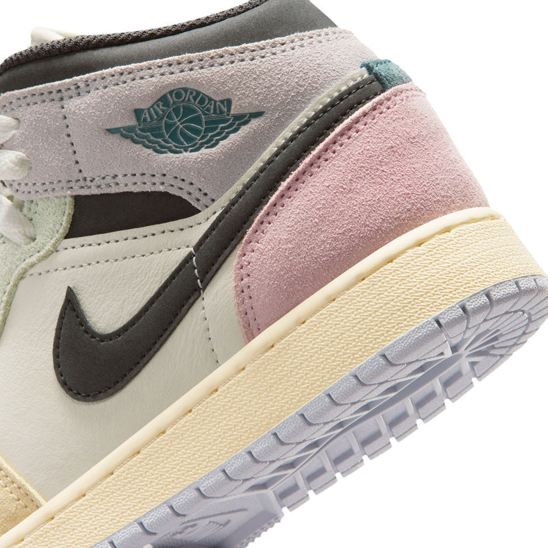 Air Jordan 1 Mid youth sneaker close-up of Air Jordan Wings logo and pink suede side panel
