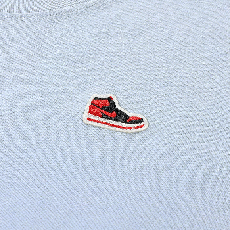 Close-up of Jordan sneaker logo patch on light blue T-shirt