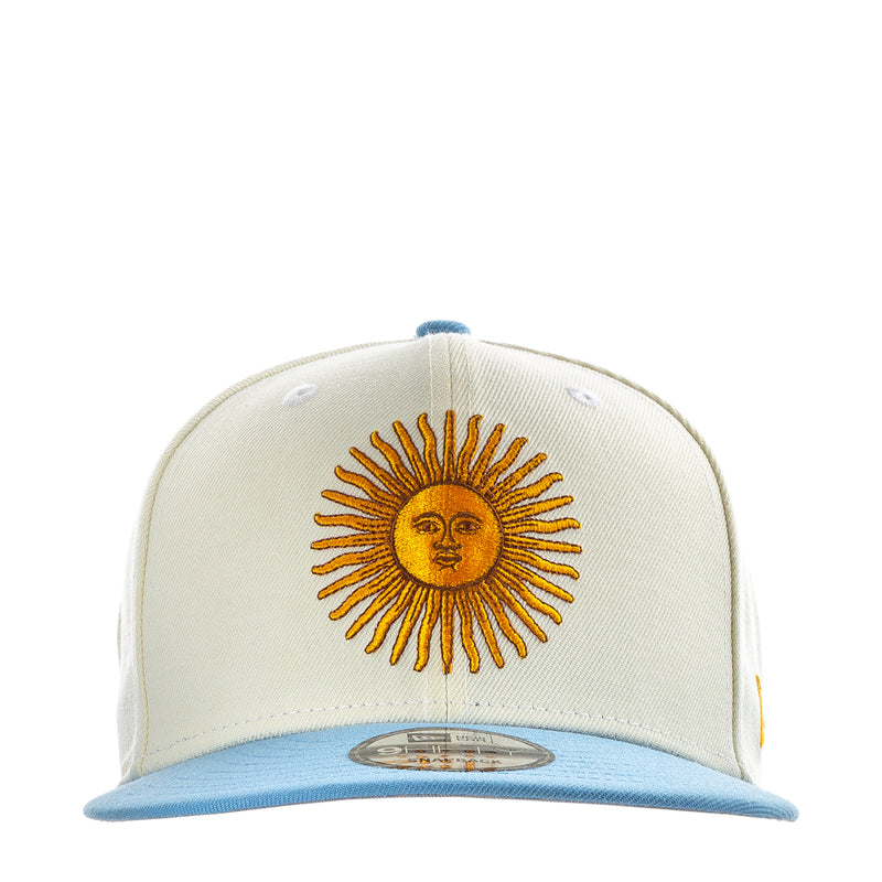 Cream baseball cap with embroidered sun face and light blue brim