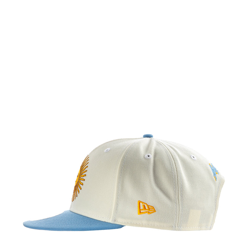 Cream baseball cap with yellow logo and light blue brim, front view