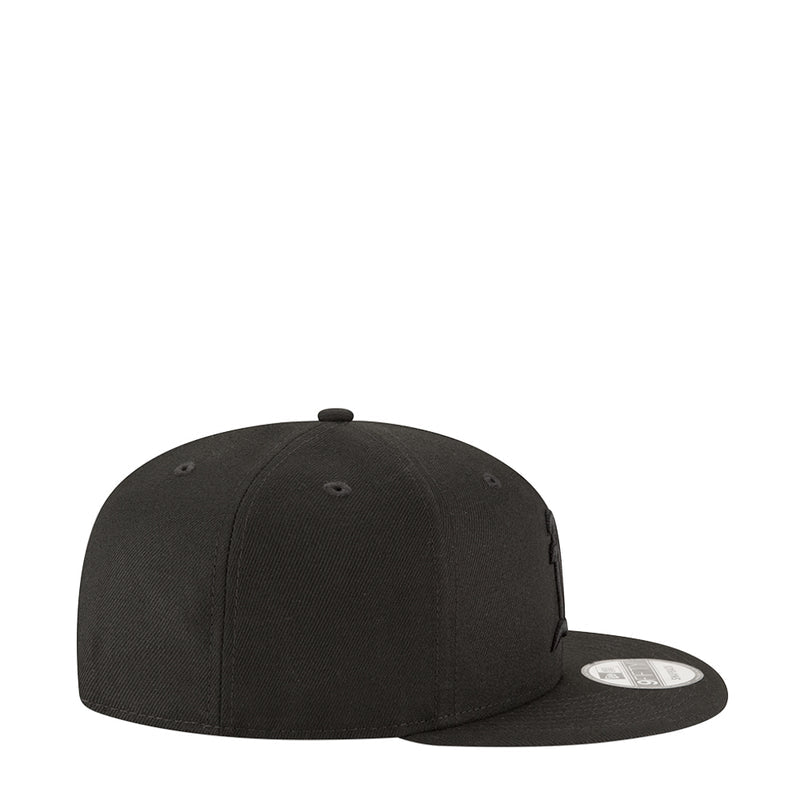 Black baseball cap with curved brim and stitched panels, side view