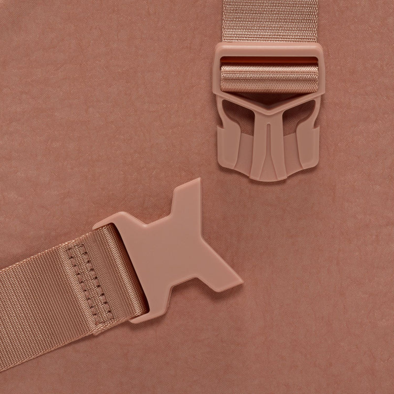 Rose gold bag hardware closeup: adjustable buckle and strap release clip