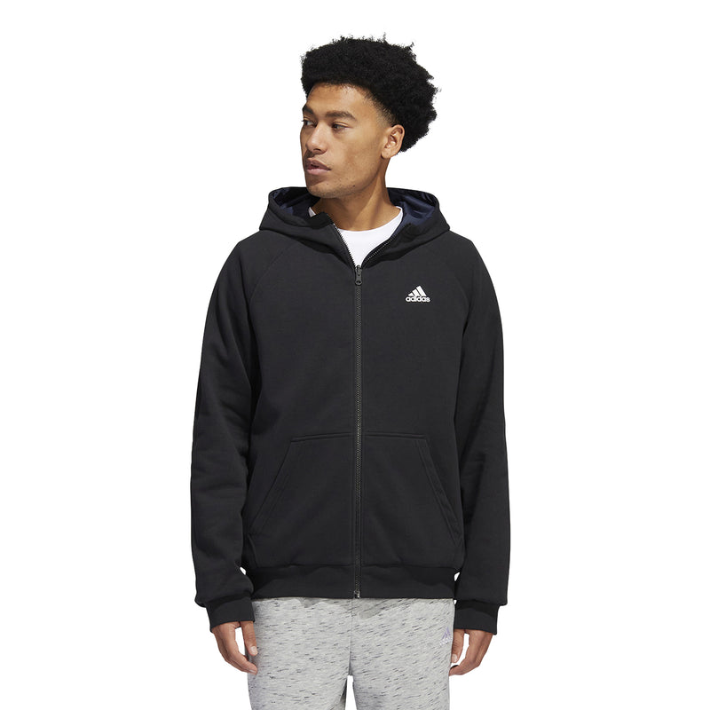 Men's black hooded zip jacket worn over light gray pants