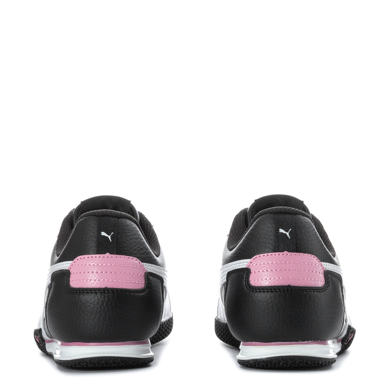 Youth Puma black sneakers with pink heel panel and white sole edge, back view.