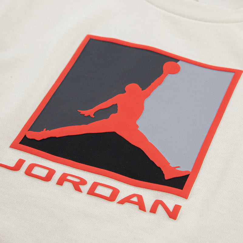 Ivory T-shirt with large Jordan block logo graphic in red and dark colors.