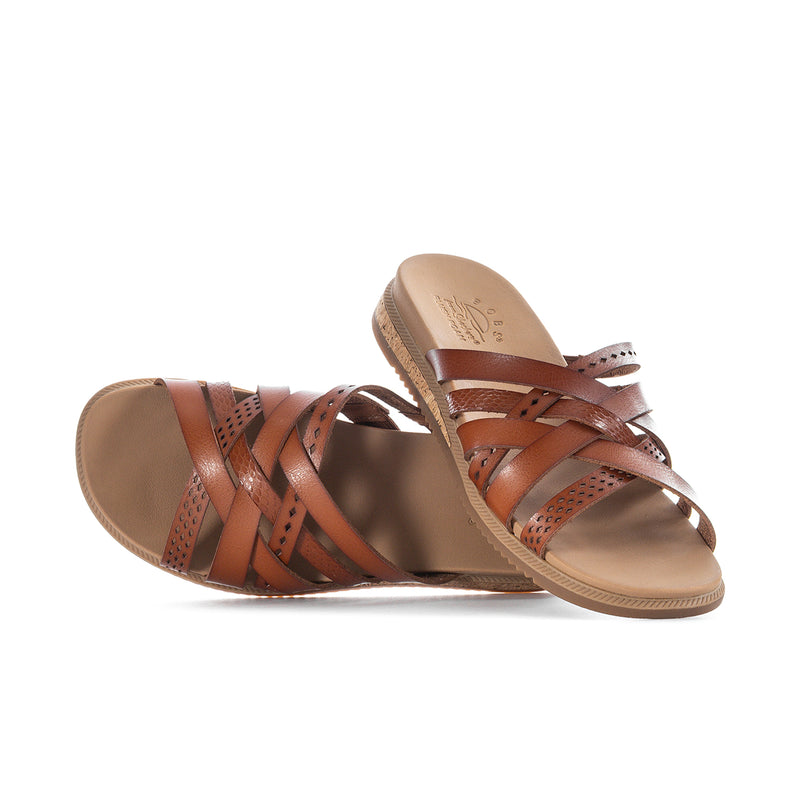 Chestnut low slide sandal with crisscross leather straps, perforations, and cushioned footbed