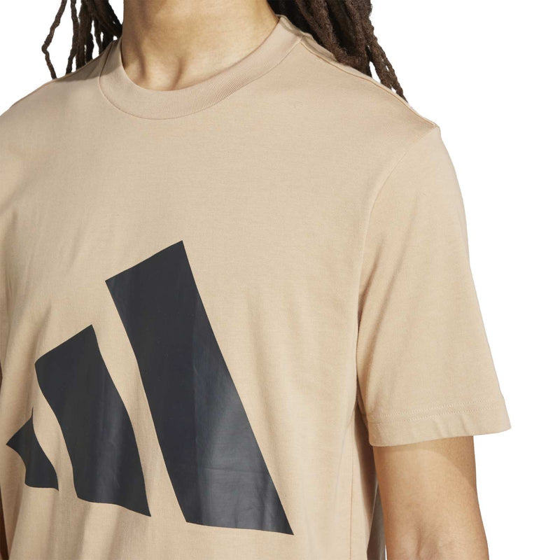 Close-up of warm sandstone T-shirt with dark logo graphic on the chest