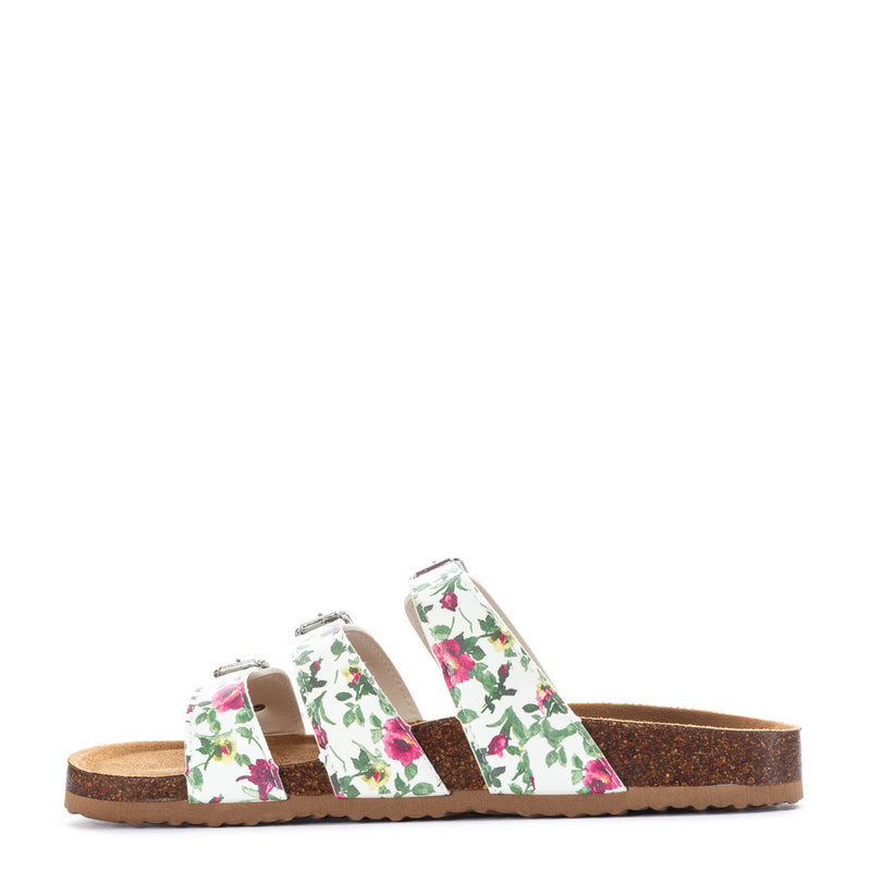 White floral slide sandal with three adjustable straps over tan cork-style footbed