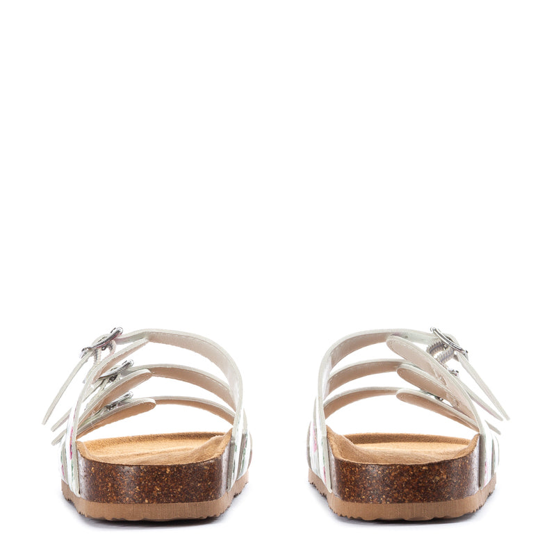 White slide sandal with open toe, metal accents, and brown textured footbed