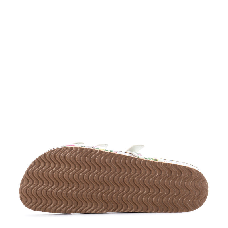 Rubber outsole of white floral slide sandal with wavy tread pattern