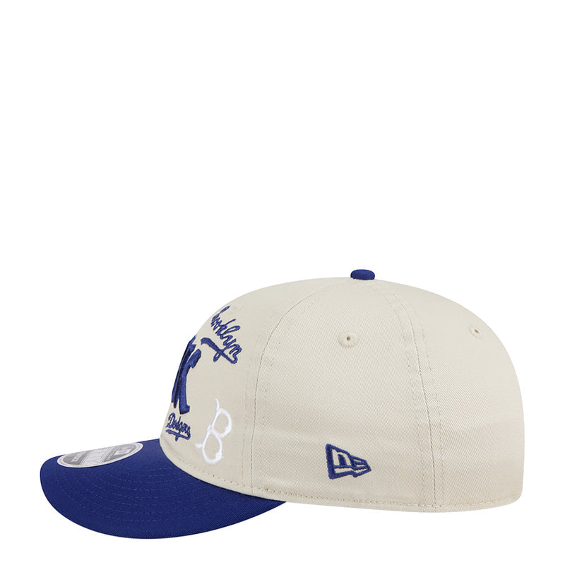 Cream baseball cap with blue side embroidery and New Era logo patch