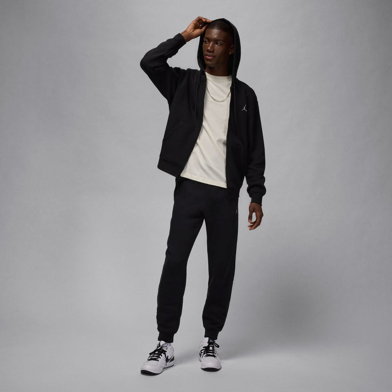 Black full-zip fleece hoodie worn with hood down, front zip and cuffed sleeves.