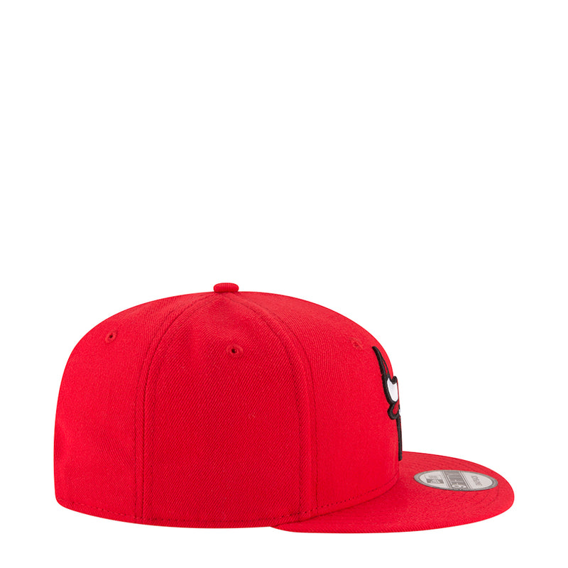 Red baseball cap side view with small embroidered bull graphic and curved brim