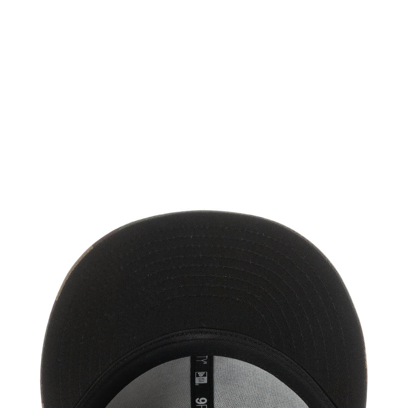 Black baseball cap crown close-up with textured fabric and seam stitching