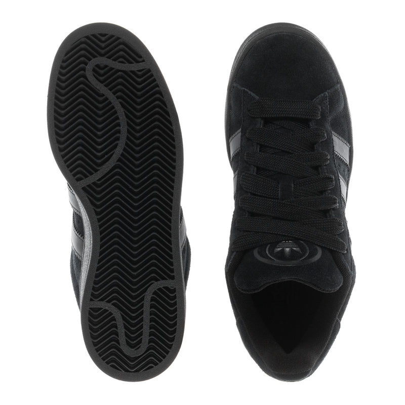 Black suede sneakers outsole and toe view showing tread pattern and lace-up upper