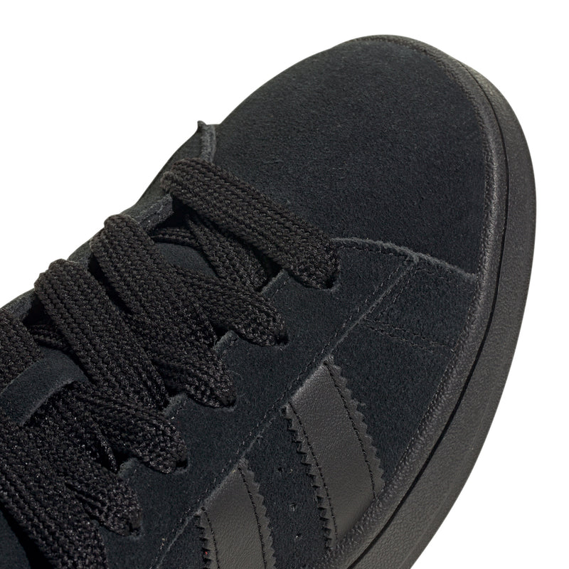 Black suede sneaker upper close-up with textured laces and three stripe overlays
