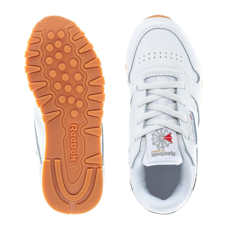 Toddler sneakers outsole view, textured gum rubber and white upper.