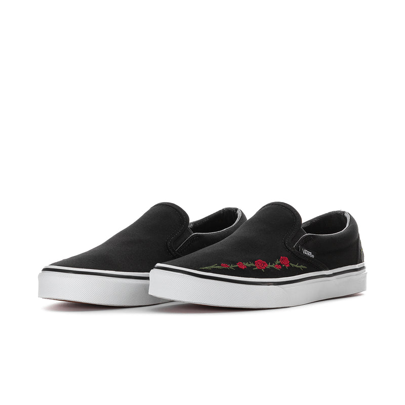 Black VANS slip-on sneakers, side view, with red rose embroidery and white sole