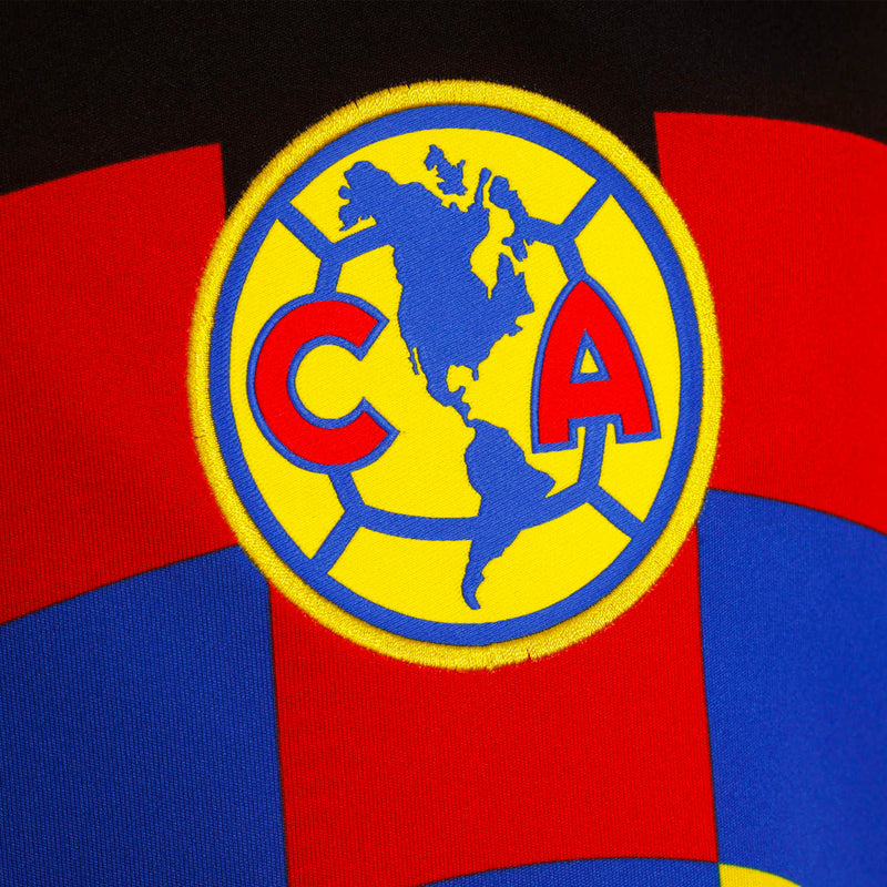 Round crest emblem on red, blue and yellow soccer jersey