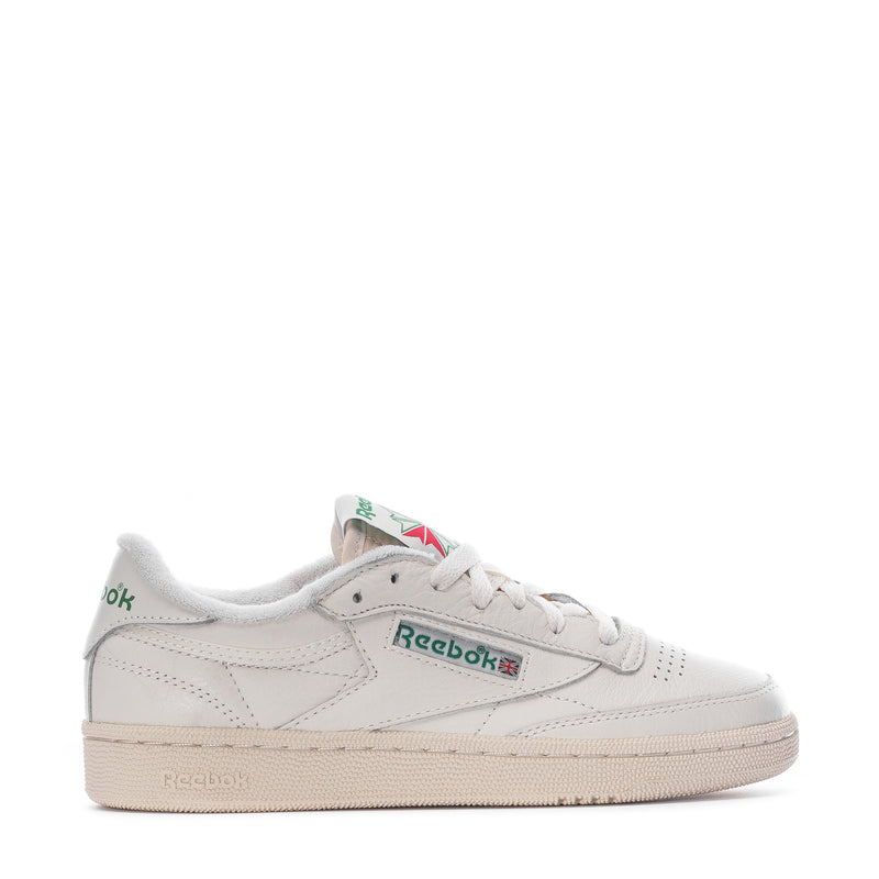 White low-top leather sneakers with Reebok logo and green tongue patch