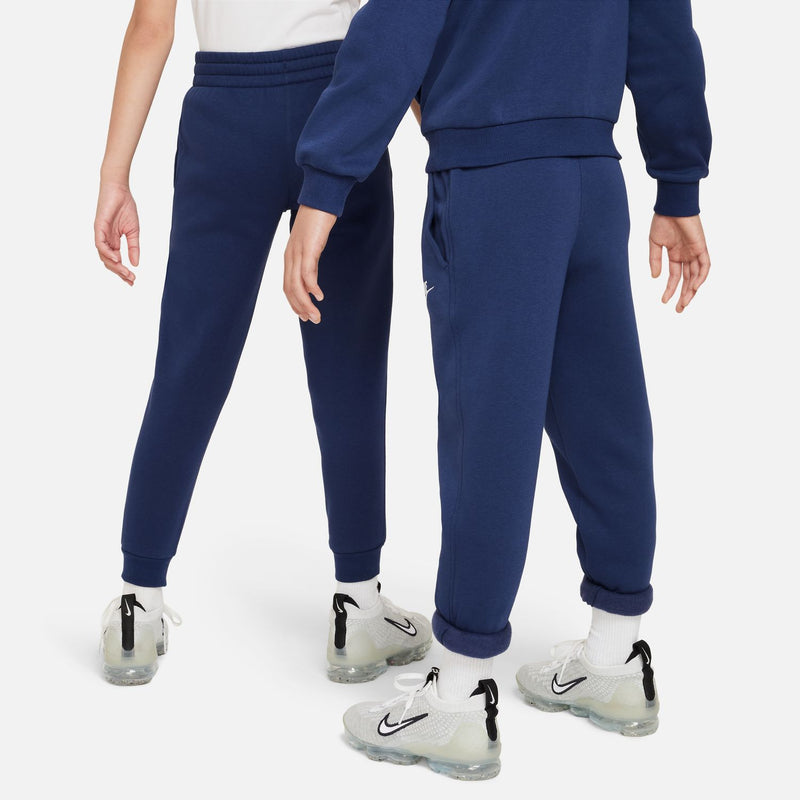 Youth midnight navy fleece jogger pants, side view with tapered cuff and Nike logo.