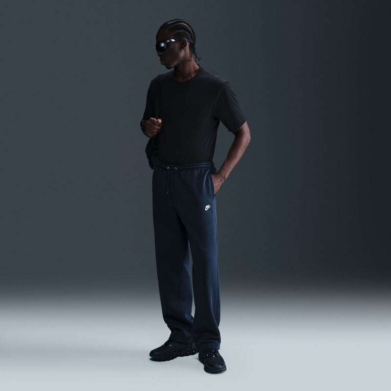 Mens dark blue fleece sweatpants with drawstring and open hems, worn with sneakers