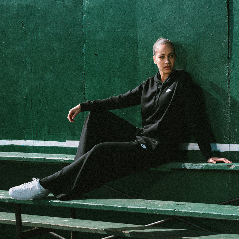 Men's black fleece pullover hoodie with Nike swoosh on chest and kangaroo pocket.