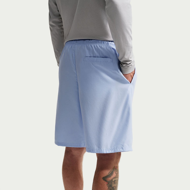 Men's light blue swim shorts close-up, back pocket seam and drawstring waist