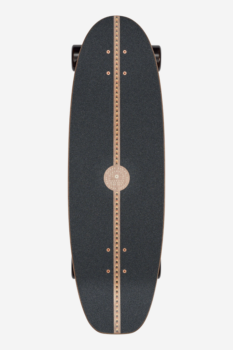 Top view of Mirage cruiserboard with dark grip tape and a vertical wooden center stripe accented by copper bolts