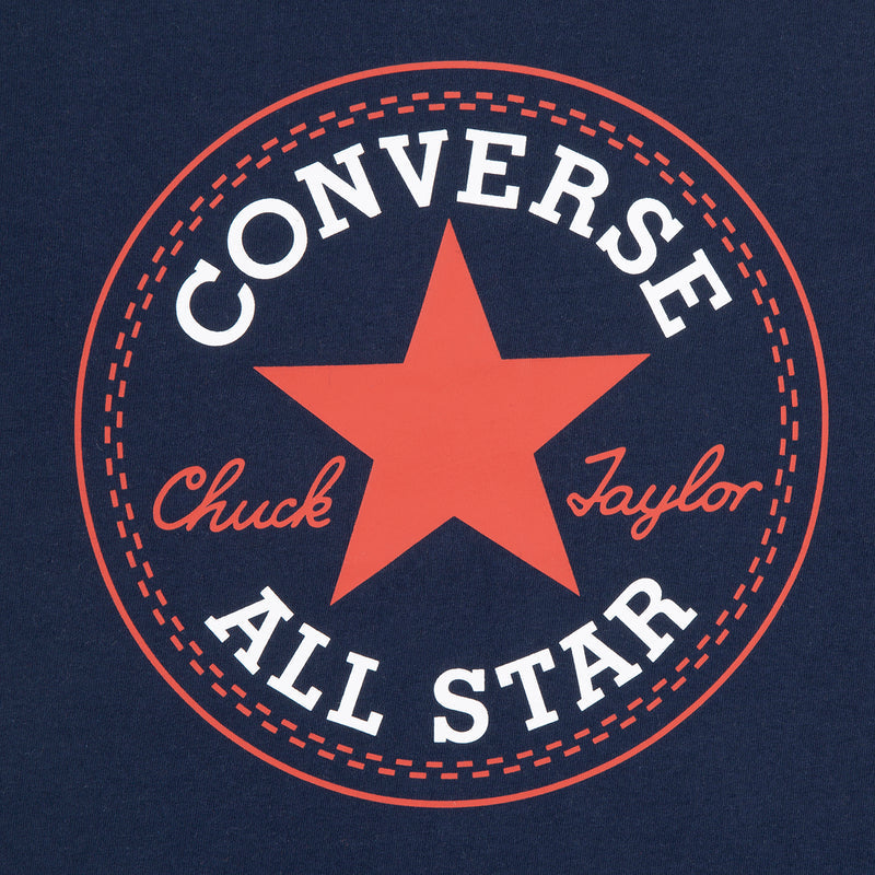 Close-up: Converse All Star circular logo with orange star on youth navy T-shirt