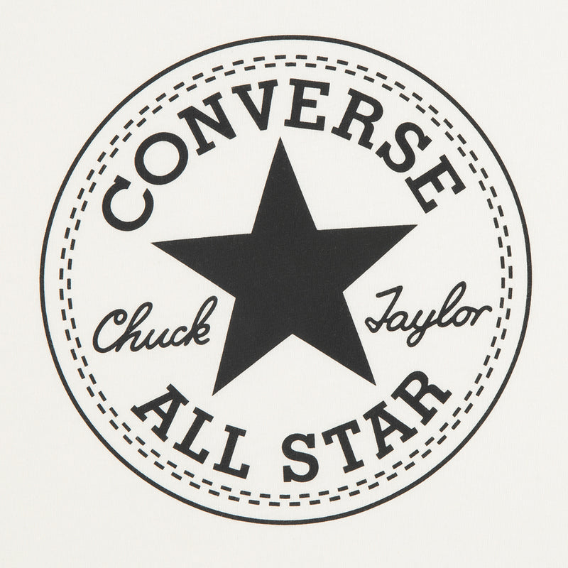Close-up of circular Converse All Star Chuck Taylor logo patch on off-white tee