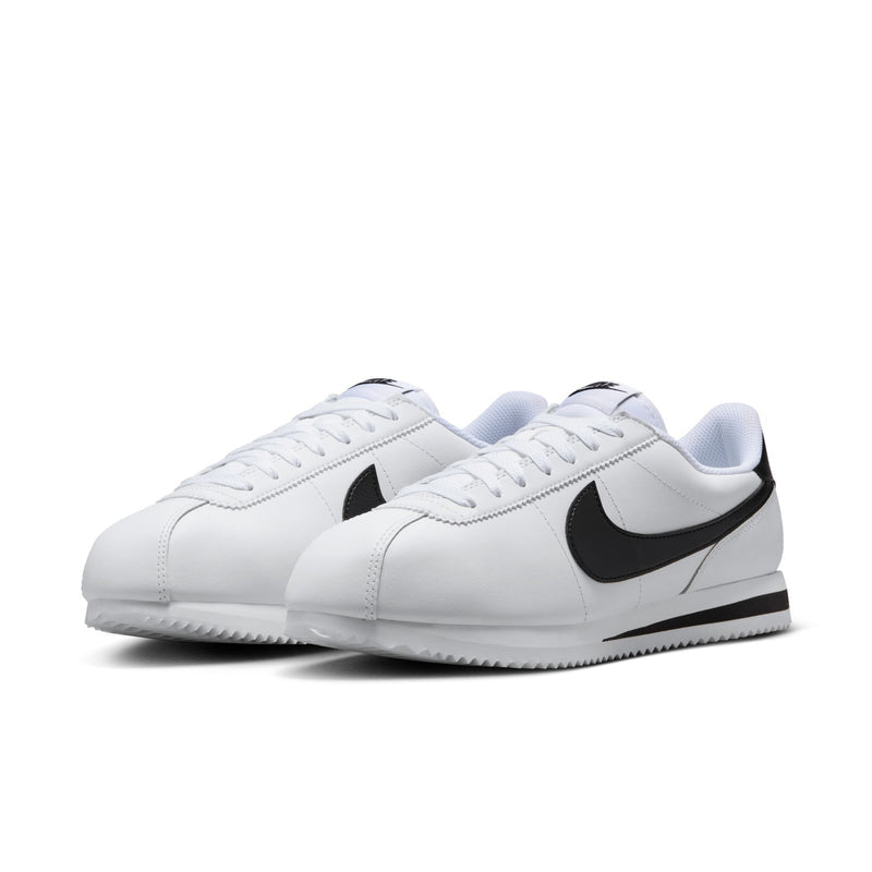Women's white low-top sneakers with black swoosh, lace-up, and textured sole