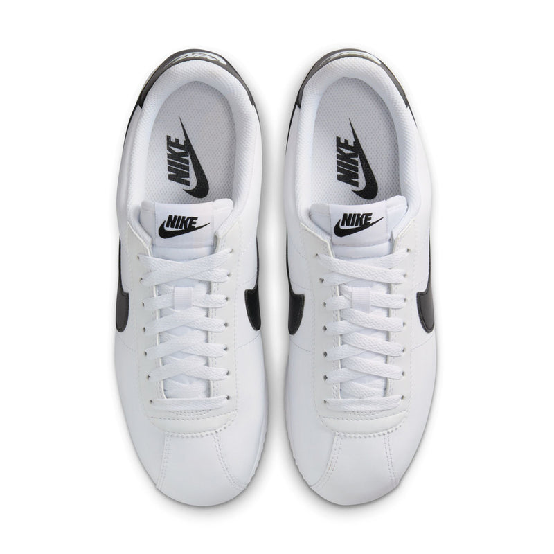 Pair of women's white low-top sneakers, white laces and Nike tongue logo