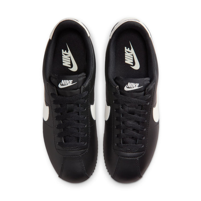 Women's NIKE Cortez sneakers with black uppers and white swoosh, lace-up view