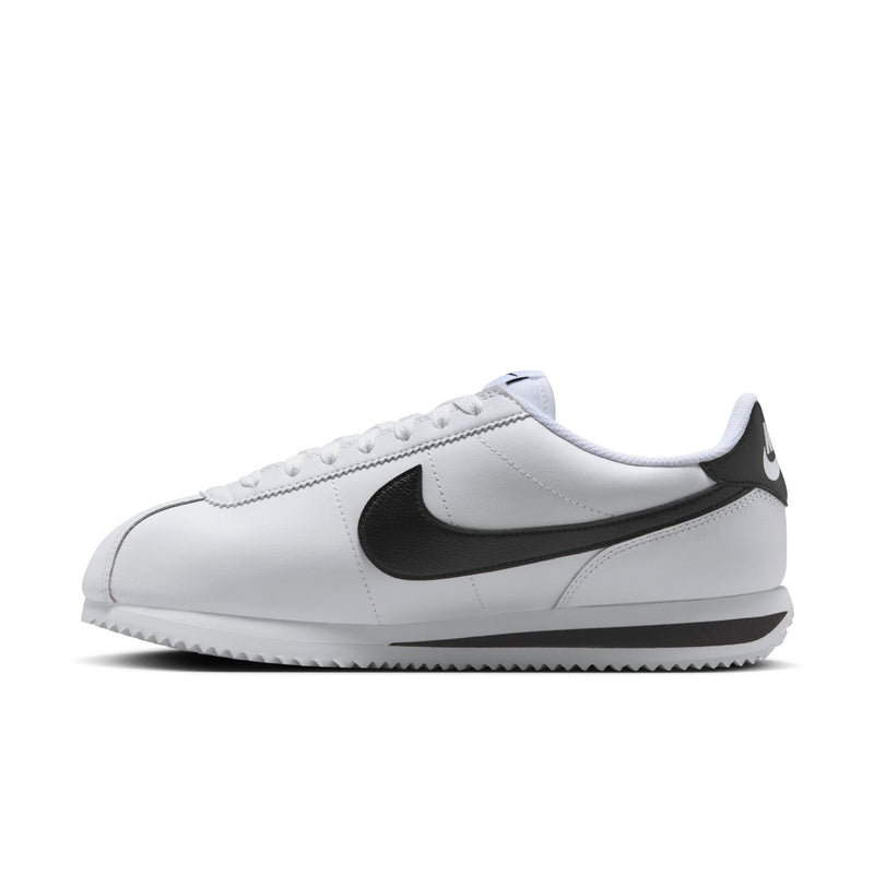 Women's white low-top sneakers with black swoosh stripe and side panel stitching