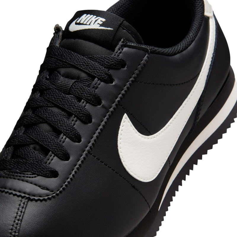 Women's NIKE Cortez sneakers close-up, black laces and white swoosh on leather upper