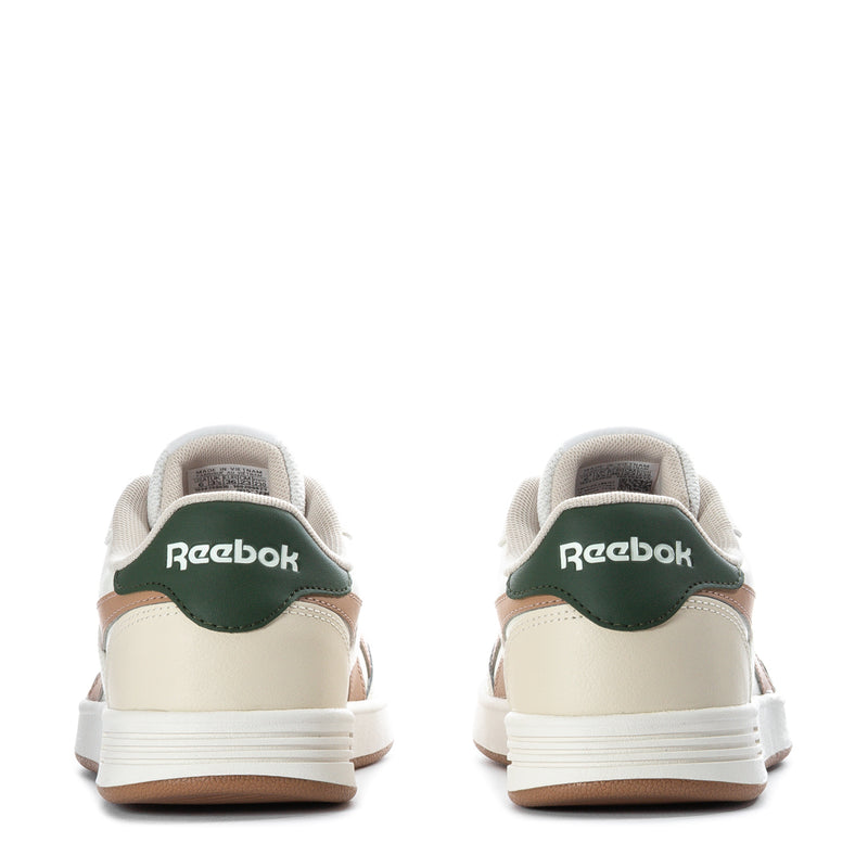 Women’s Reebok sneakers heel view, white with tan panels and green heel tab; gum sole.