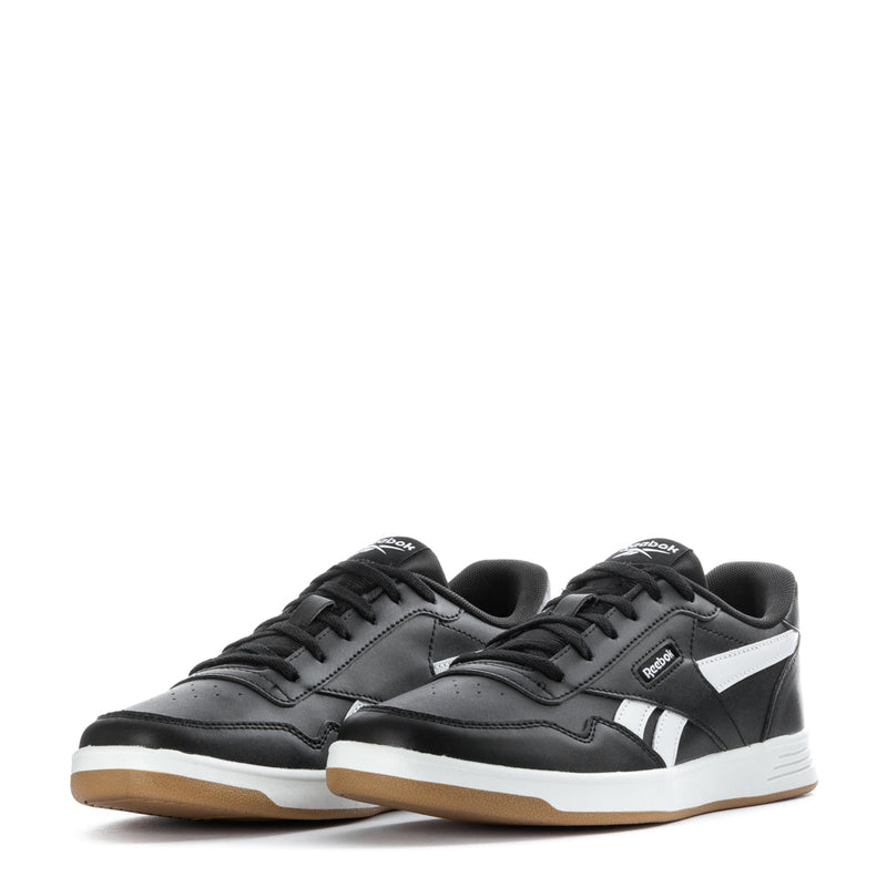 Black youth Reebok Court Advance low-top sneakers with white accents and gum sole.