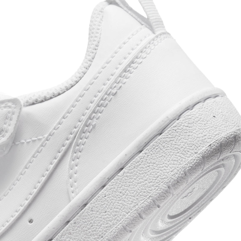 White kids low-top sneakers, side view with textured panels and swoosh logo