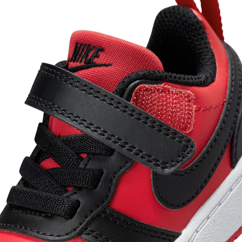 Close-up of toddler Nike red sneaker with black Velcro strap and textured lining