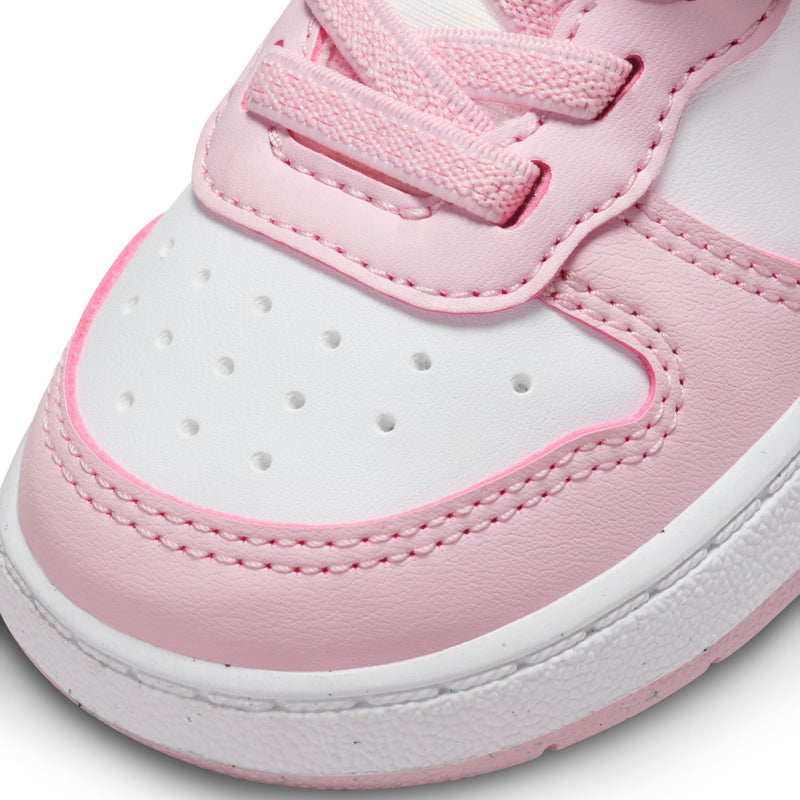 Toddler sneaker close-up: white and pink upper with perforations and stitched stripes.