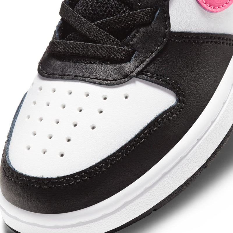 Kids mid-top sneaker close-up: perforated white toe, black laces, pink lining detail