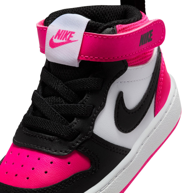 Toddler sneaker close-up: Nike logo strap, black laces, white panel, fierce pink