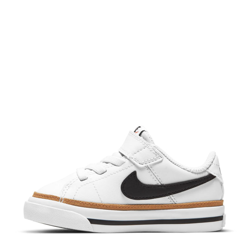 Toddler low-top sneakers with white upper, black swoosh, tan stripe, strap closure
