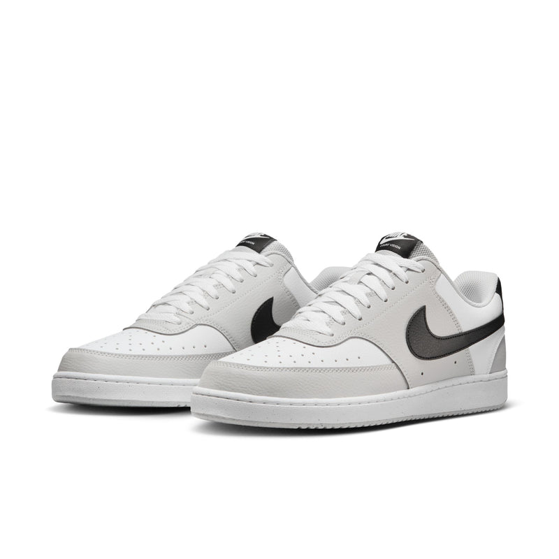 Pair of low-top men's sneakers in white with gray and black swoosh accents, lace-up.
