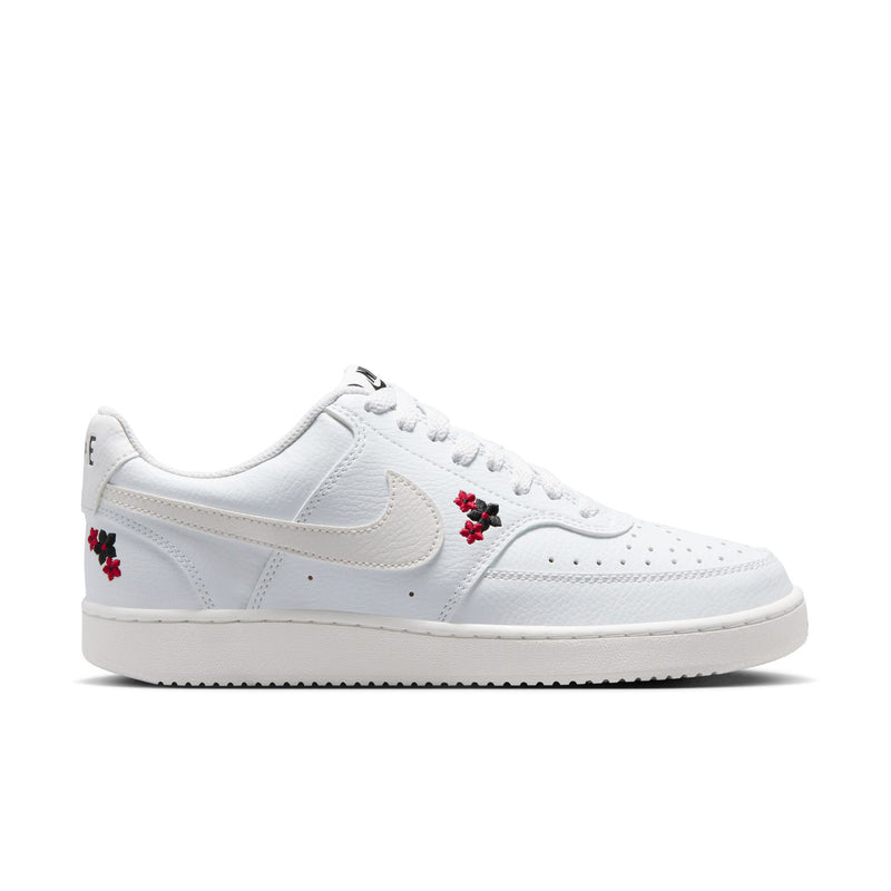 Women's low-top sneaker in off-white with red flower accents and Nike swoosh