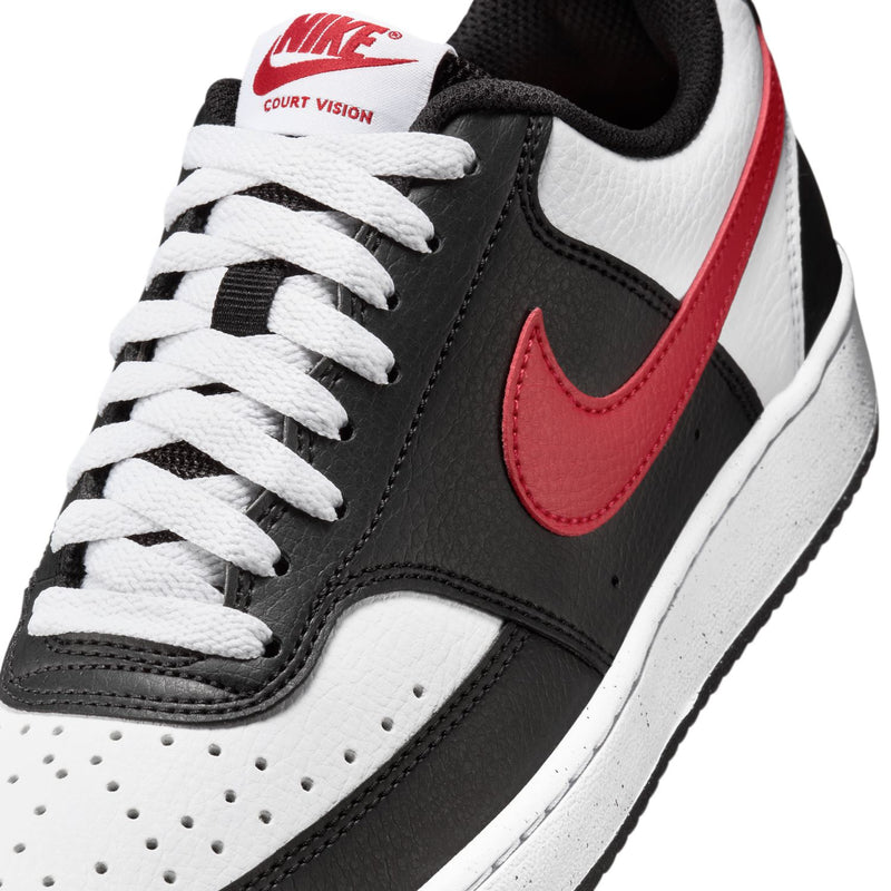 Women's low-top sneaker close-up: black and white with red swoosh, lace-up.