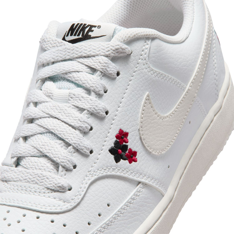 Close-up of off-white sneaker upper with red flower embroidery and Nike swoosh
