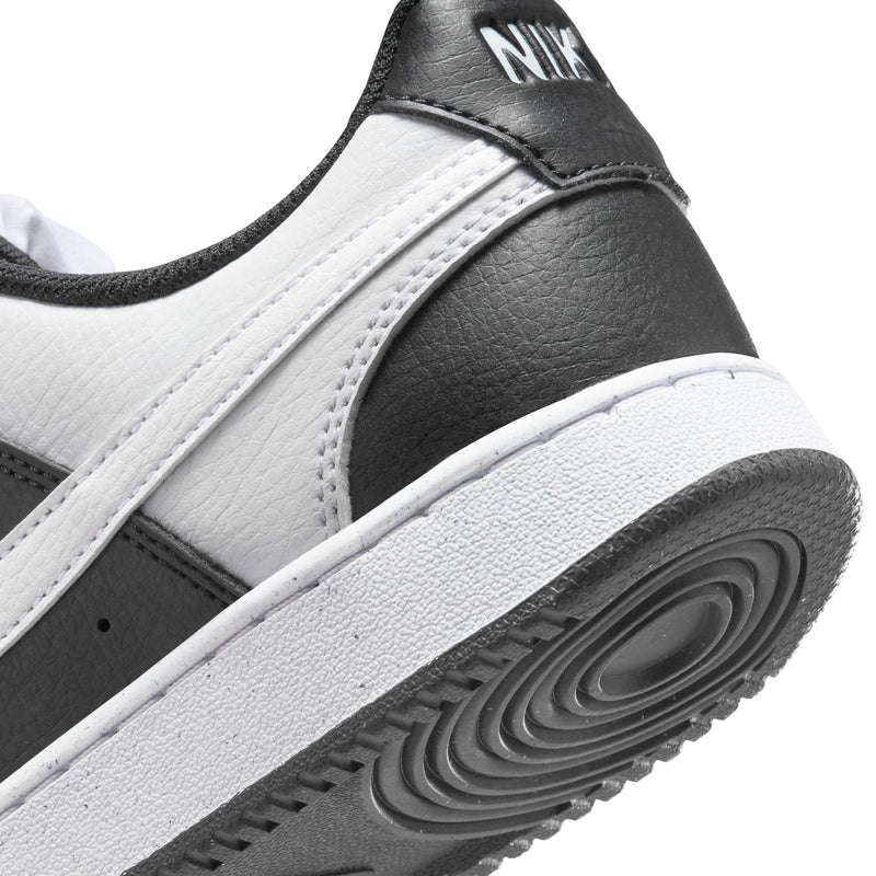 Women's sneaker outsole close-up; black sole with tread and white midsole edge