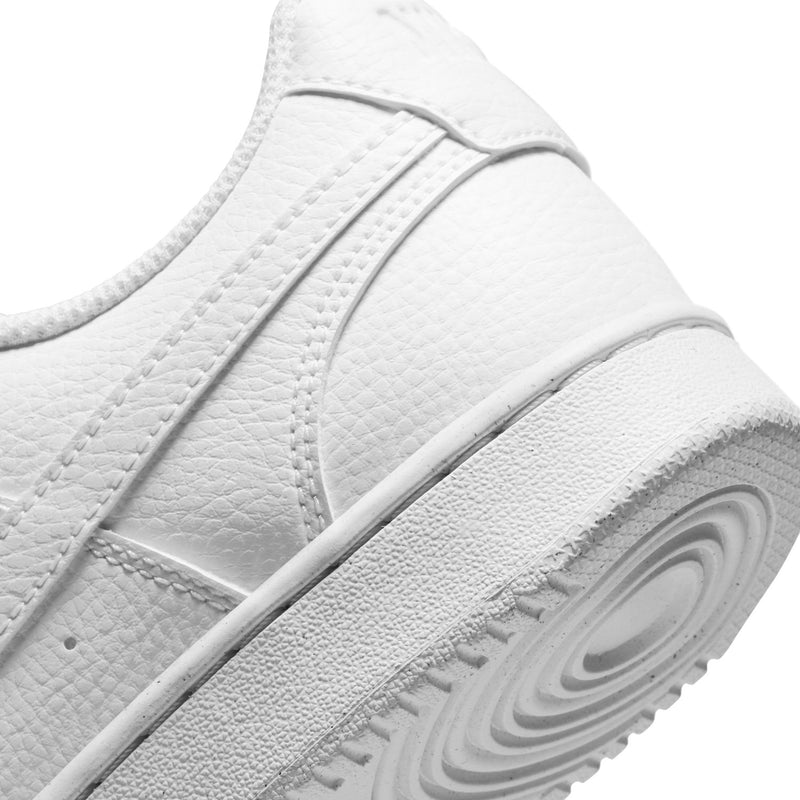 Close-up of white sneaker side with textured panels and swoosh detail